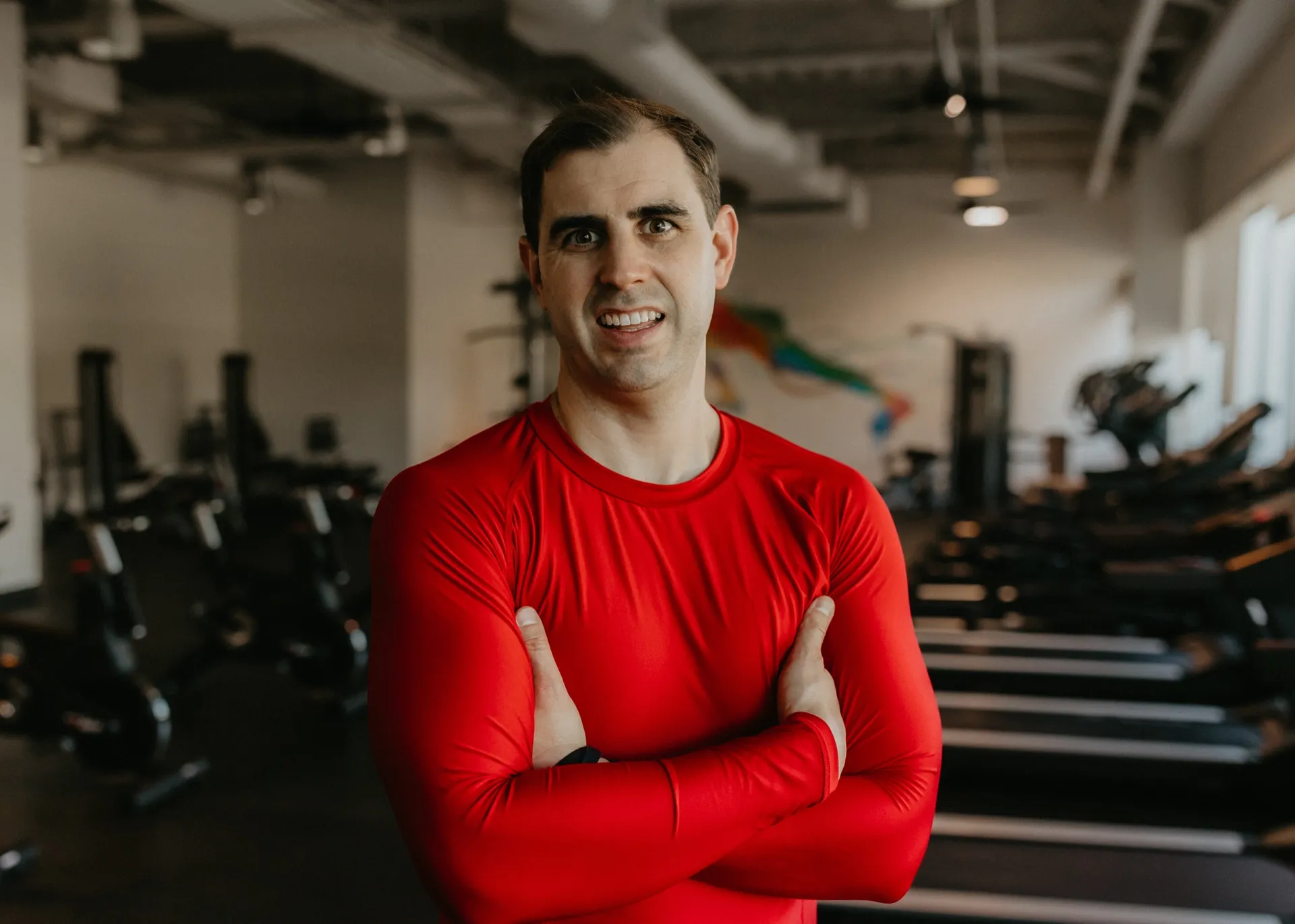 Nathan Brennan standing with arms crossed in a training facility