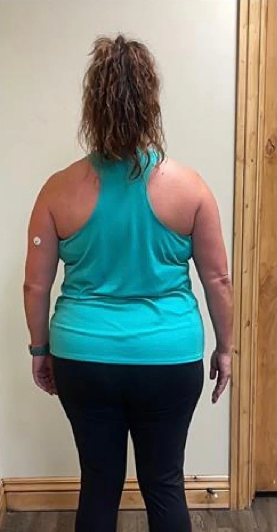 The same client photographed from behind after coaching with Nathan Brennan, with a narrower waist and squarer shoulders